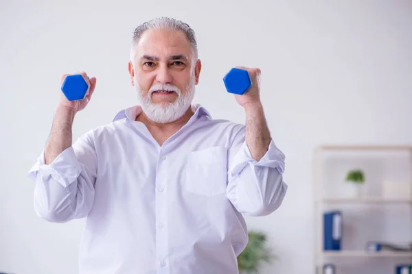 Mola sırasında fiziksel egzersiz yapan yaşlı bir erkek. — Stok fotoğraf