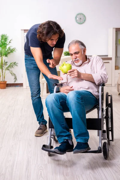 Tekerlekli sandalyedeki yaşlı adam ve genç kötü bakıcı.