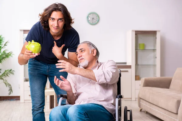 Tekerlekli sandalyedeki yaşlı adam ve genç kötü bakıcı.