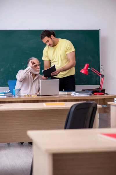 Starý učitel a mladý muž student ve třídě — Stock fotografie