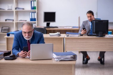 Ofiste çalışan iki erkek çalışan.