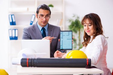 Genç işadamı ve bayan mimar yeni projeyi tartışıyor