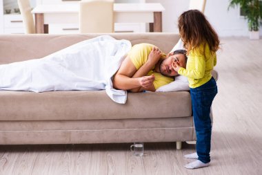 Küçük kız hasta babasına bakıyor.