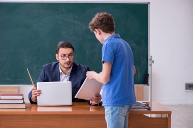 Genç erkek öğretmen ve okul çocuğu sınıfta.