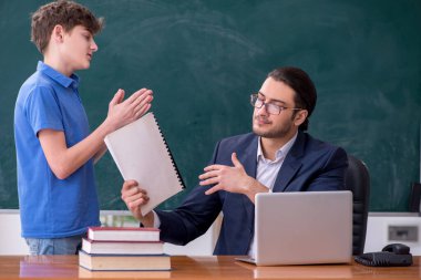 Genç erkek öğretmen ve okul çocuğu sınıfta.