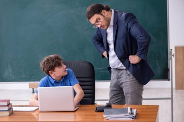 Genç erkek öğretmen ve okul çocuğu sınıfta.