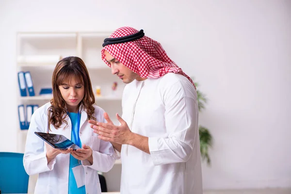 Fiatal arab üzletember látogató kaukázusi női orvos — Stock Fotó