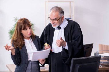 Yaşlı erkek yargıç ve genç sekreteri ofiste.