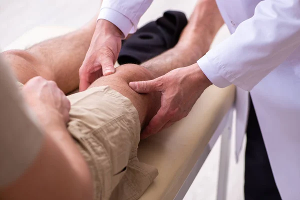 Experienced doctor traumatologist examining young male patient — Stock Photo, Image