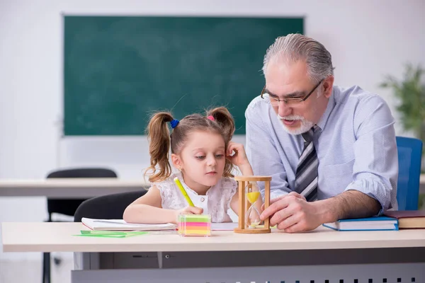 Oude leraar en schoolmeisje op school — Stockfoto