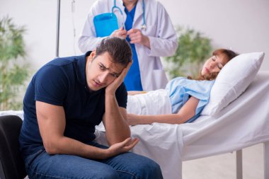 Genç koca, hasta karısını klinikte ziyaret ediyor.