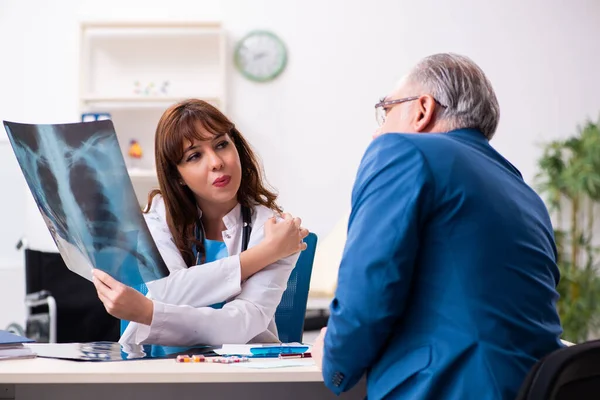 Oude zakenman bezoekt jonge vrouwelijke arts — Stockfoto