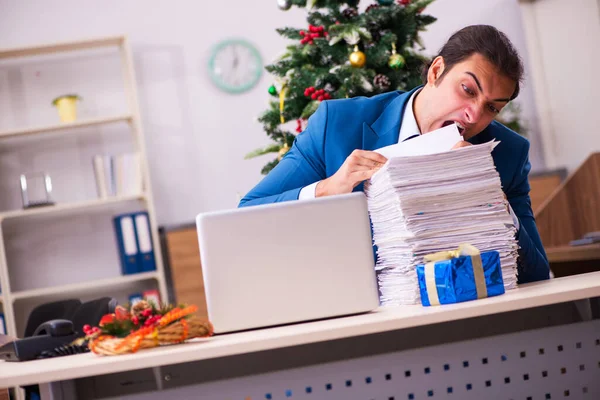 Mladý muž zaměstnanec pracující v kanceláři na Vánoce — Stock fotografie