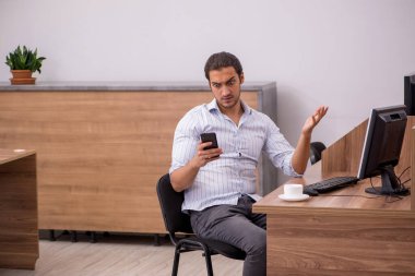 Genç bir erkek işçi aşırı işten memnun değil.