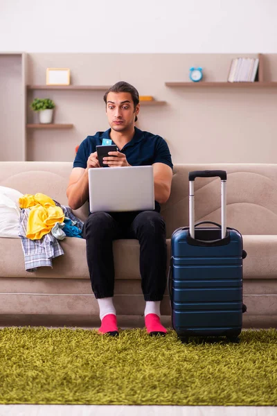 Ung man förbereder sig för resa hemma — Stockfoto