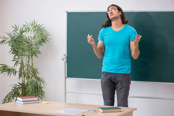 Joven estudiante masculino frente al tablero verde —  Fotos de Stock