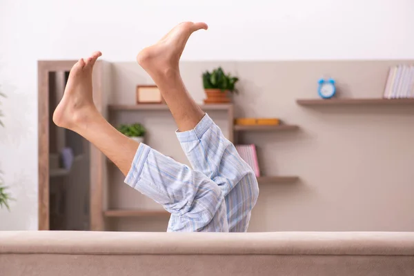 Jeune homme paresseux dans un concept de sommeil excessif à la maison — Photo