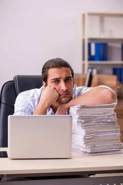 Joven empleado masculino infeliz con el trabajo excesivo — Foto de Stock