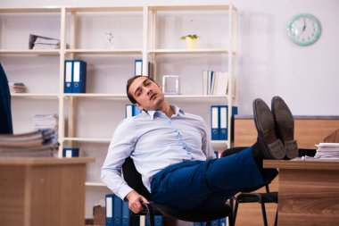 İş yerinde acı çeken genç bir erkek işçi.