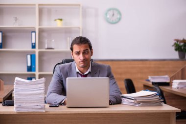 Genç erkek çalışan aşırı çalışmaktan son derece yoruldu.