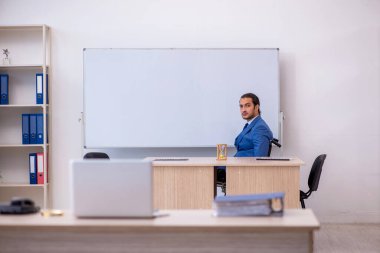 Ofiste çalışan, tekerlekli sandalyede çalışan genç bir erkek.