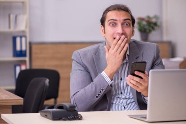 Ofiste çalışan genç bir erkek.