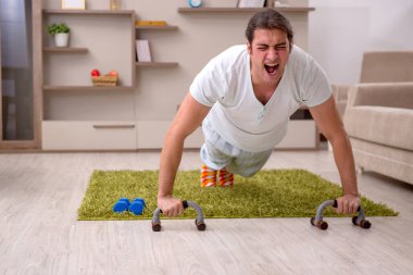 Genç adam evde spor yapıyor.