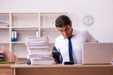 Ofisteki aşırı işten memnun olmayan genç bir erkek işçi.