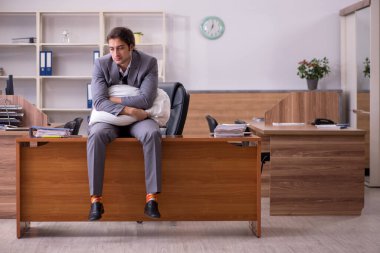 İş yerinde uyuyan genç bir erkek işçi.