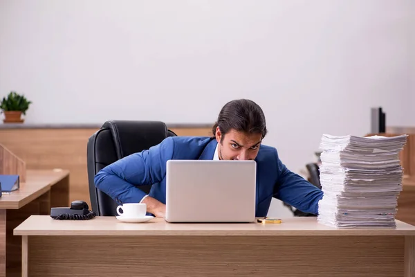 Jeune employé masculin mécontent du travail excessif au bureau — Photo