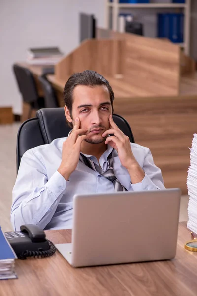 Joven empleado masculino descontento con el trabajo excesivo en la oficina — Foto de Stock