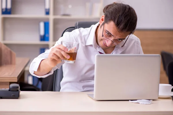 Fiatal férfi alkalmazott alkoholt iszik az irodában — Stock Fotó