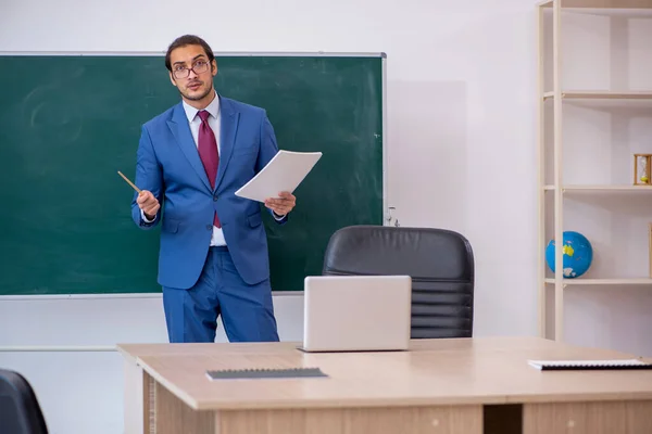 Junger männlicher Lehrer im Anzug vor grünem Brett — Stockfoto