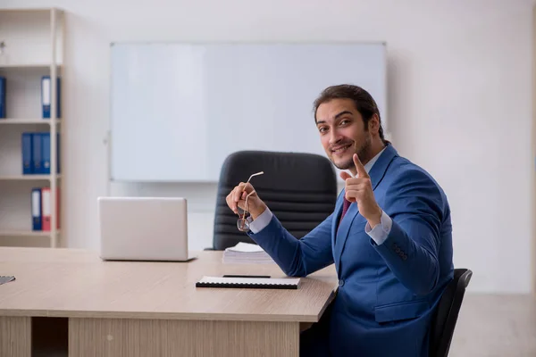 Junge männliche Mitarbeiter sitzen im Büro vor Whiteboard — Stockfoto