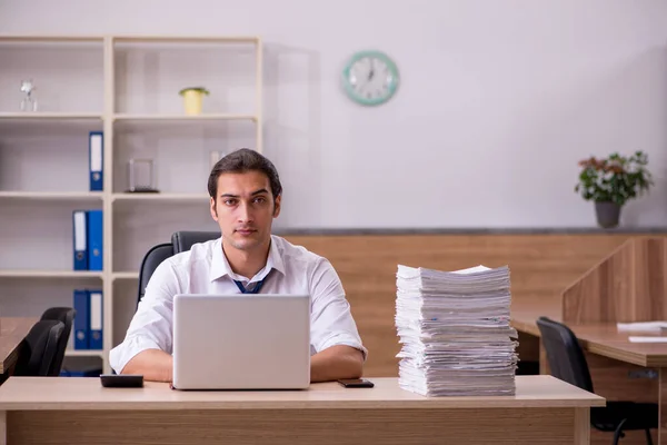 Giovane dipendente maschio infelice con un lavoro eccessivo in ufficio — Foto Stock