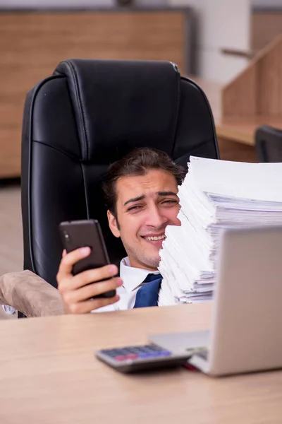 Jovem funcionário masculino infeliz com excesso de trabalho no escritório — Fotografia de Stock