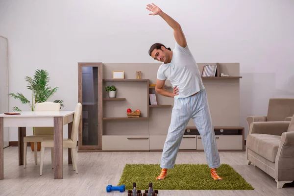 Jeune homme faisant des exercices sportifs à la maison — Photo