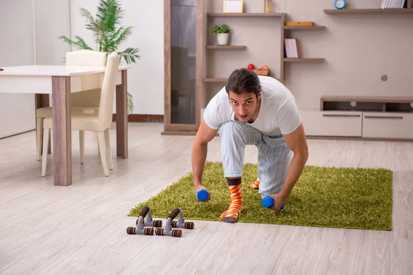 Jeune homme faisant des exercices sportifs à la maison — Photo