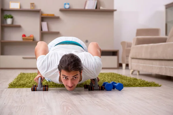 Ung man gör sport övningar hemma — Stockfoto