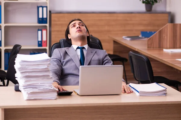 Jovem funcionário masculino infeliz com excesso de trabalho no escritório — Fotografia de Stock