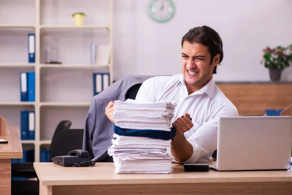 Joven empleado masculino descontento con el trabajo excesivo en la oficina — Foto de Stock