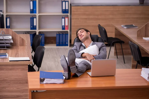 Jovem empregado dormindo no local de trabalho — Fotografia de Stock