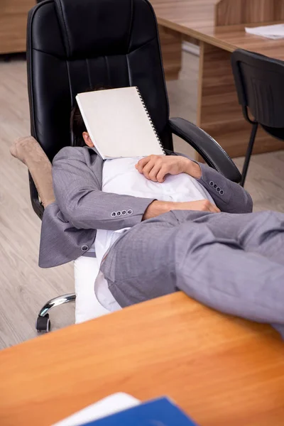 Jeune employé masculin dormant sur le lieu de travail — Photo
