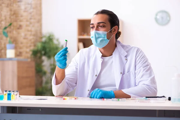 Jovem químico do sexo masculino trabalhando no laboratório durante a pandemia — Fotografia de Stock