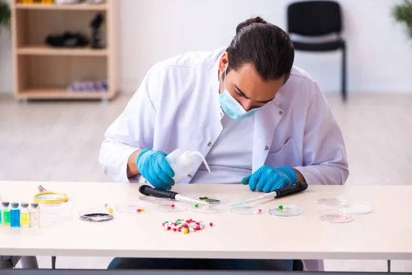 Joven químico masculino trabajando en el laboratorio durante una pandemia —  Fotos de Stock