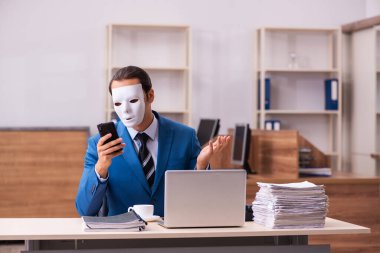 Ofiste maske takan genç bir erkek.