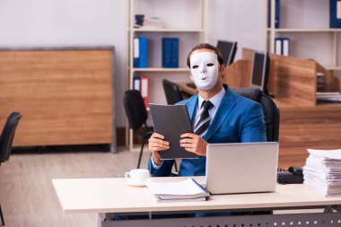 Ofiste maske takan genç bir erkek.