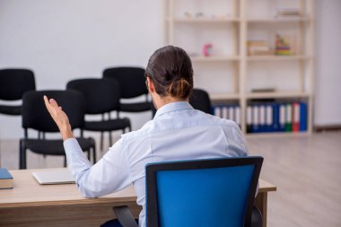 Genç erkek patron salgın sırasında ofiste seminer veriyor.