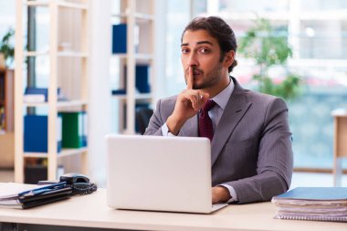 Ofiste çalışan genç bir erkek.