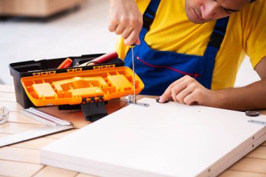 Genç erkek marangoz içeride çalışıyor.